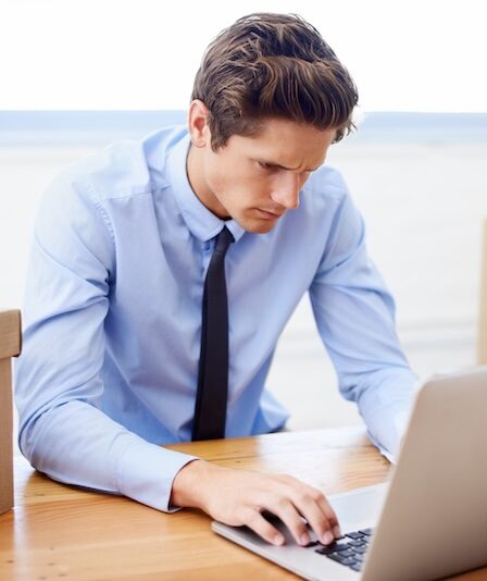 Man på kontor vid laptop med flyttlådor runt